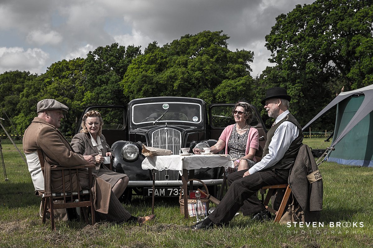 Britain Does Vintage Stody Lodge Norfolk photographer steven brooks photographs Britain Does Vintage at Stody Lodge two couples sitting around picnic table in vintage clothes