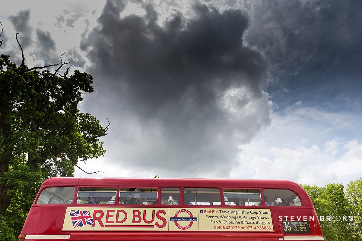 Britain Does Vintage Stody Lodge Norfolk photographer steven brooks photographs a red bus roof under dark clouds at Britain Does Vintage at Stody Lodge