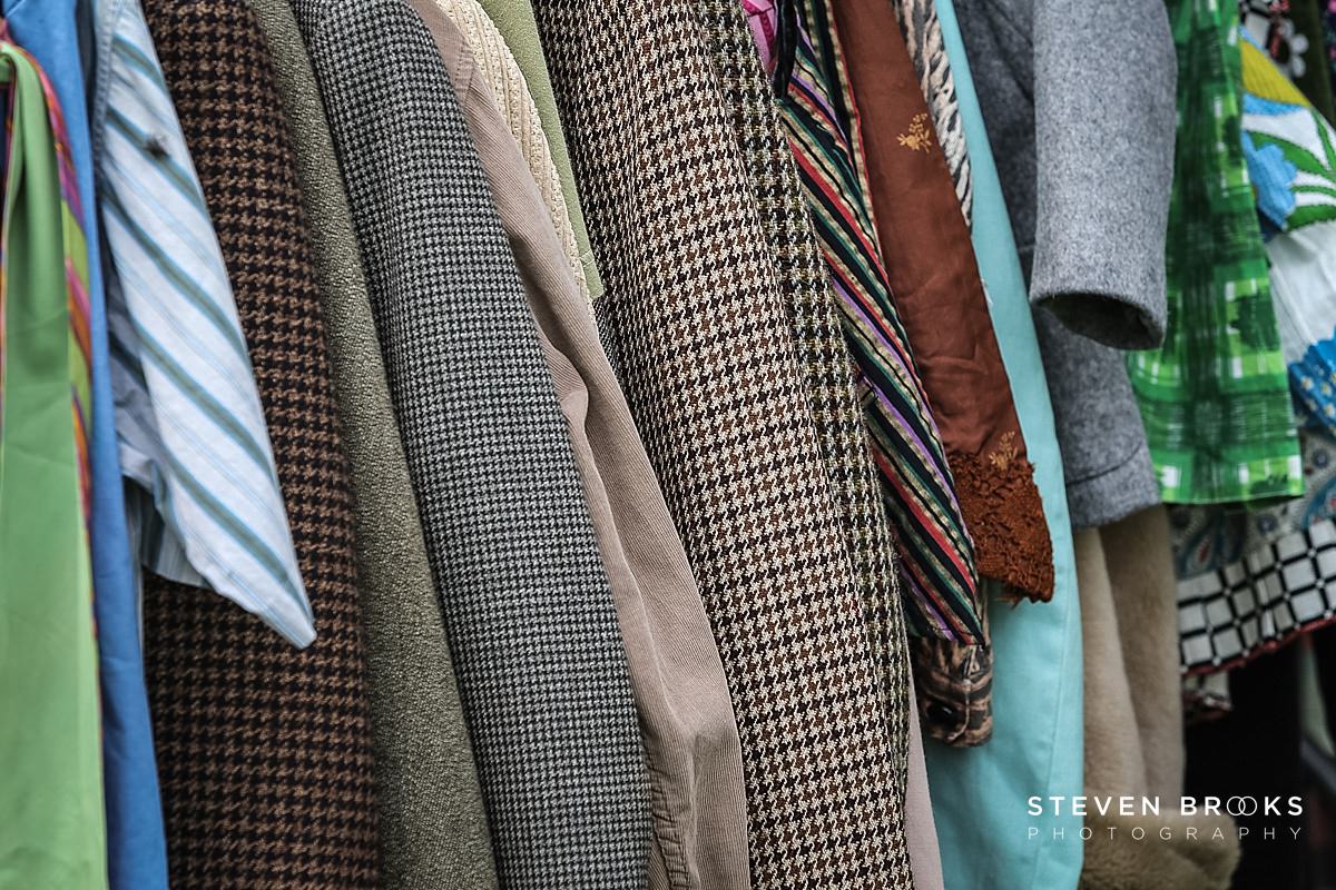 Britain Does Vintage Stody Lodge Norfolk photographer steven brooks photographs a of tweed jackets on a rack at Britain Does Vintage in Norfolk