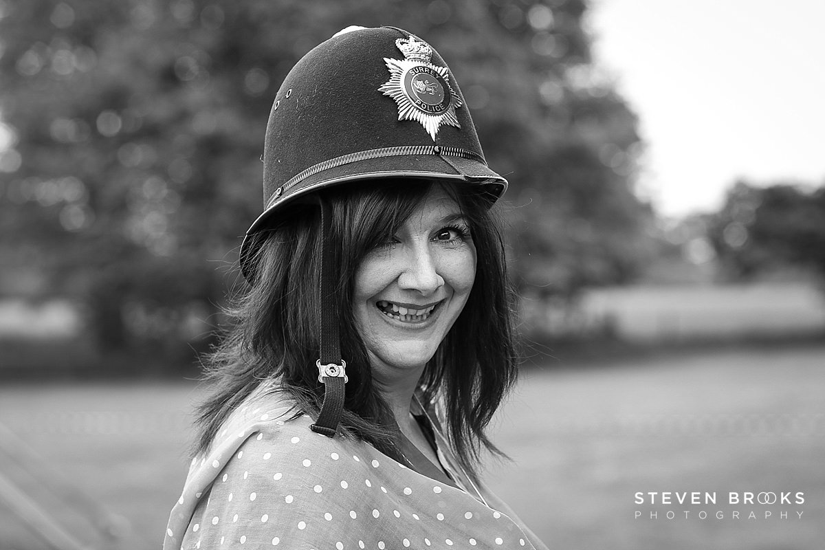 Britain Does Vintage Stody Lodge Norfolk photographer steven brooks photographs a womans in an old policemans helmet at Britain Does Vintage in Norfolk