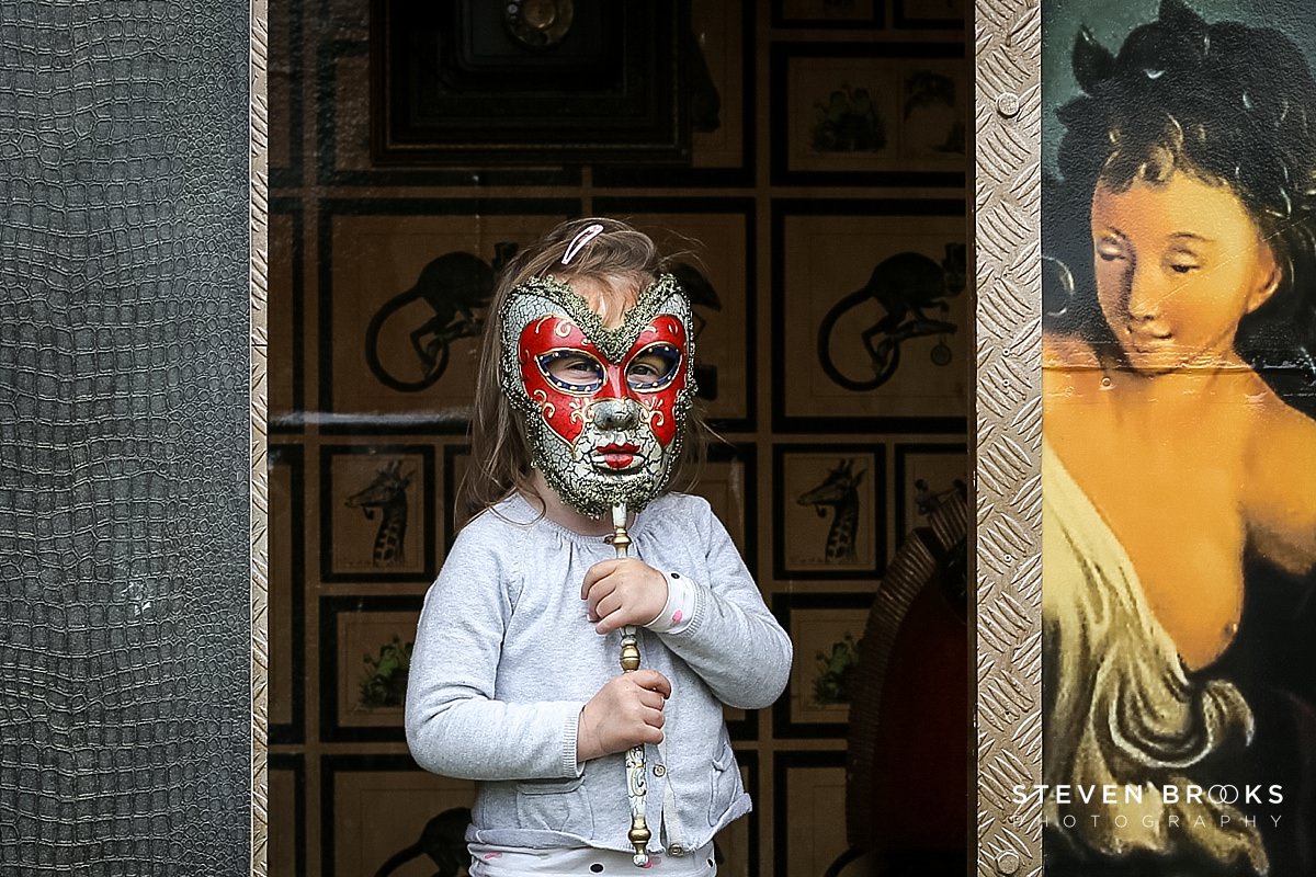 Britain Does Vintage Stody Lodge Norfolk photographer steven brooks photographs a child holding a venetian mask at Britain Does Vintage in Norfolk